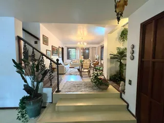 Interior de uma sala de estar com escadaria em um imóvel em Lajeado.