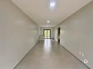 Foto do corredor interno de uma residência com piso de cerâmica.