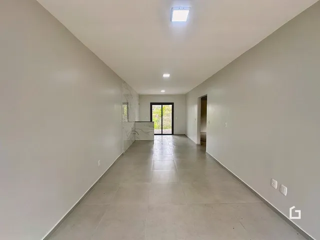 Foto do corredor interno de uma residência com piso de cerâmica.