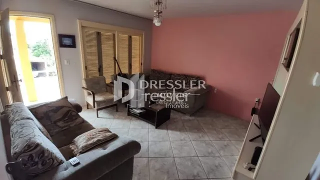 Sala de estar com sofá e portas de madeira em um imóvel no Brasil.