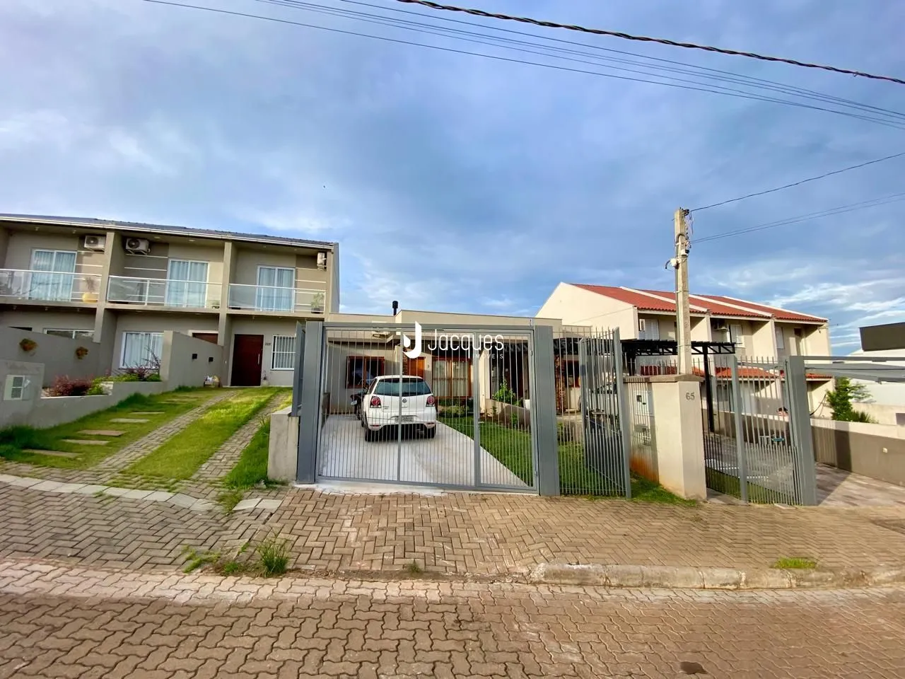 Fachada de uma residência em Lajeado, Brasil, com portão de ferro e área externa.