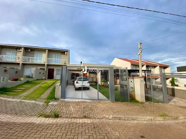 Fachada de uma residência em Lajeado, Brasil, com portão de ferro e área externa.
