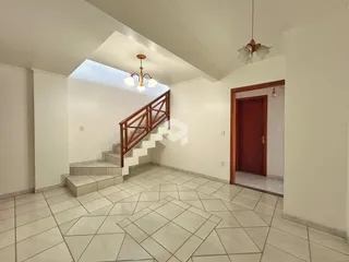 Hall com escadaria e piso de cerâmica.