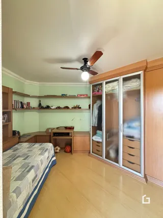 Foto de um quarto com armários embutidos e piso de madeira clara.