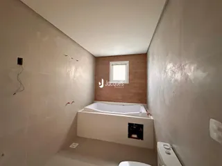 Foto de um banheiro com banheira em um ambiente interno.