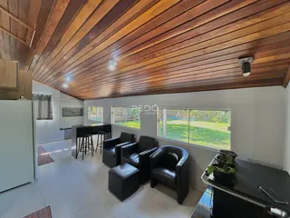 Sala de estar com piso de madeira e vista para o jardim.