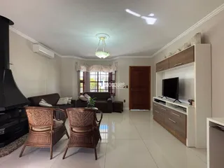 Sala de estar com lareira e móveis de madeira no interior da residência.