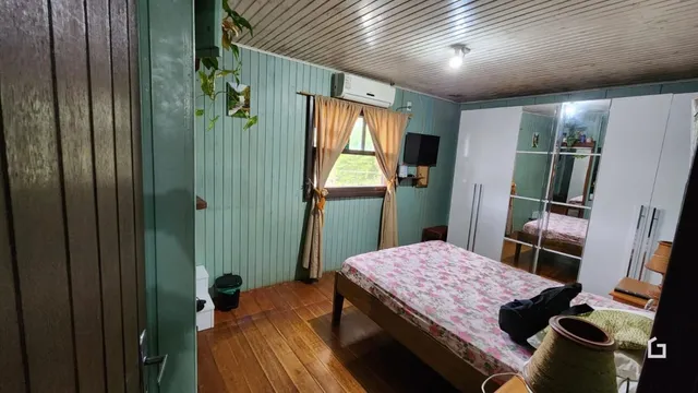 Quarto com cama e janela em ambiente interno.