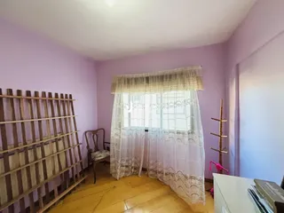 Quarto com paredes roxas e piso de madeira em Lajeado, Brasil.