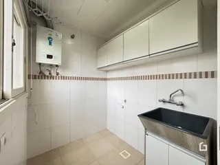 Uma cozinha com revestimento de azulejos brancos e bancada escura.