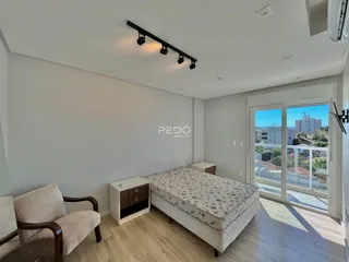 Quarto com vista para a cidade e acesso a uma varanda.
