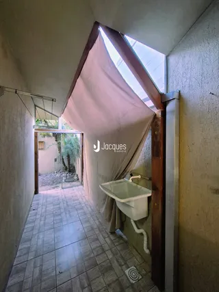 Corredor interno com piso de cerâmica e parede clara.