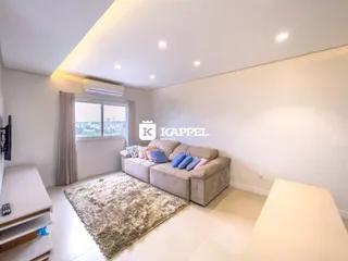 Sala de estar com sofá e janela em um apartamento.
