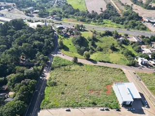 Vista aérea de uma área de terreno com vegetação e estrada.