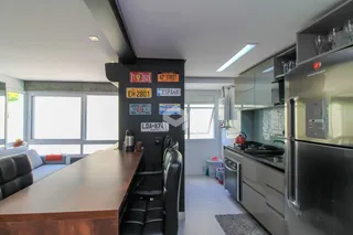 Ambiente interno de uma sala de estar e cozinha em uma residência.