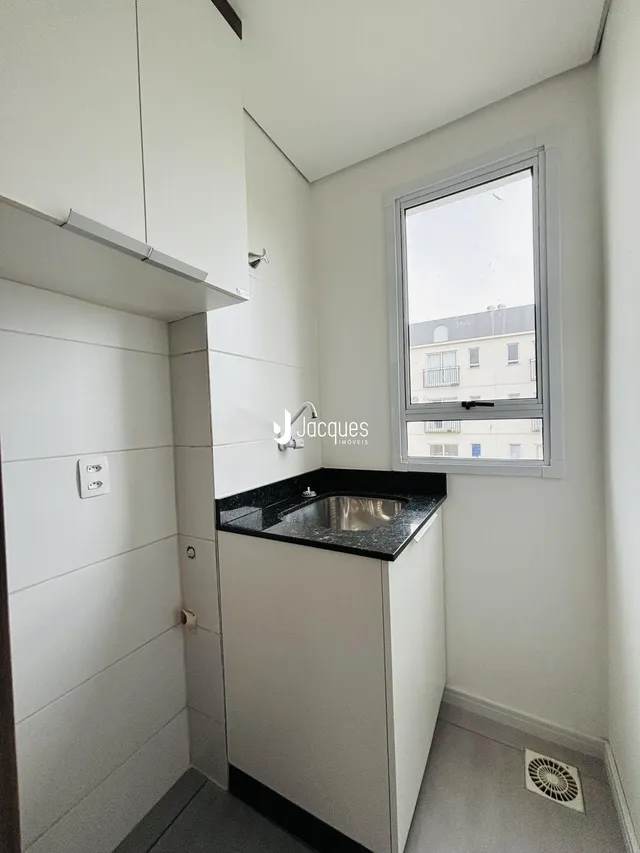 Foto de um banheiro moderno com revestimento branco e bancada escura.