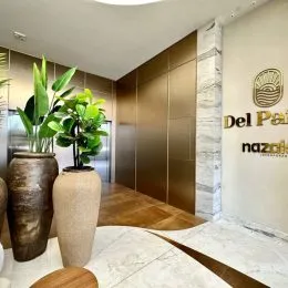 Hall de entrada com plantas e painéis verticais de madeira.