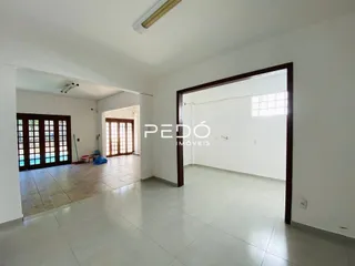 Vista interna de um corredor com piso de cerâmica e portas de madeira.