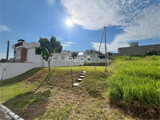 Vista externa de uma propriedade com gramado e cerca no Brasil.