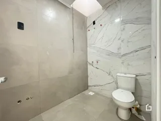 Foto de um banheiro com revestimento de azulejos claros nas paredes.