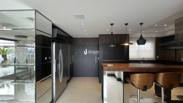 Interior de uma cozinha moderna com armários escuros e ilha central.
