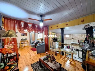 Sala de estar com piso de madeira e cortinas vermelhas.
