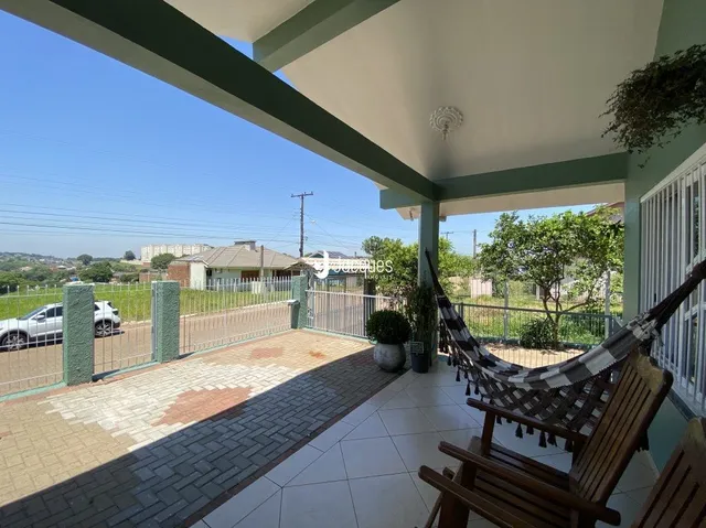 Vista de uma área externa com piso de ladrilhos e grade de segurança.