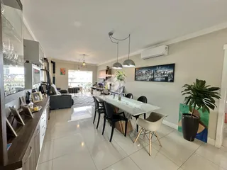 Sala de estar e jantar de um apartamento moderno com piso de cerâmica.