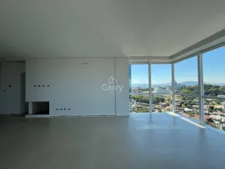 Uma sala ampla com grandes janelas oferece uma vista panorâmica da paisagem urbana.