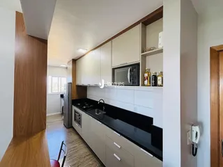 Foto de uma cozinha com armários brancos e bancada escura.