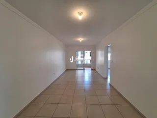 Corredor interno com piso de cerâmica claro.