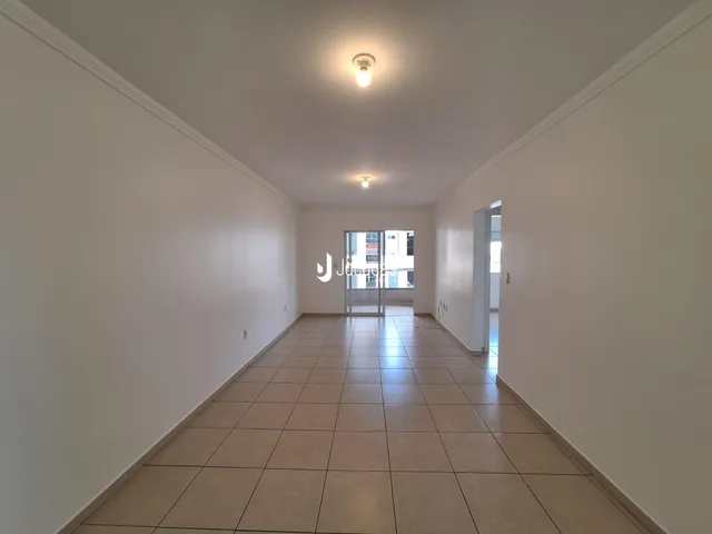 Corredor interno com piso de cerâmica claro.