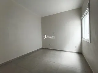 Vista interna de um ambiente com paredes brancas e piso de cerâmica.