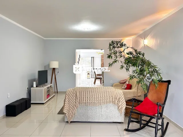 Sala de estar com sofá e televisão em um ambiente interno.