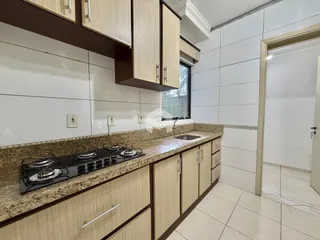 Foto de uma cozinha com armários de madeira e revestimento branco.
