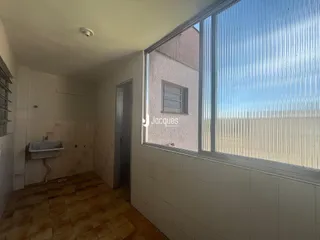 Vista interna de um corredor com piso de cerâmica e janela grande.