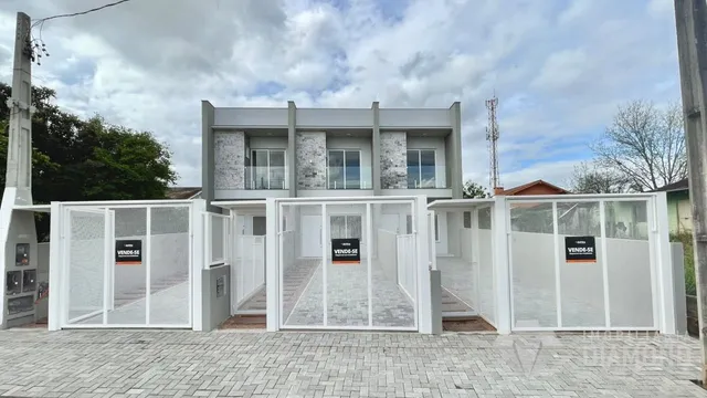 Fachada de uma residência em Lajeado, Brasil, com portões brancos de metal.