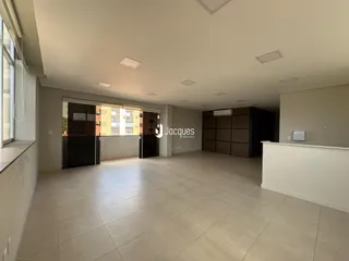 Interior de uma grande sala com piso de cerâmica clara.