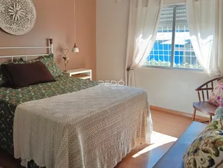 Quarto com cama e janela em ambiente residencial.