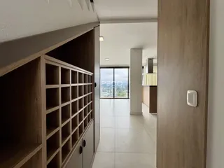 Hall de entrada com piso de cerâmica e portas de madeira.