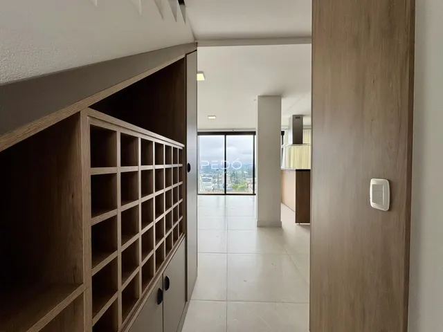 Hall de entrada com piso de cerâmica e portas de madeira.