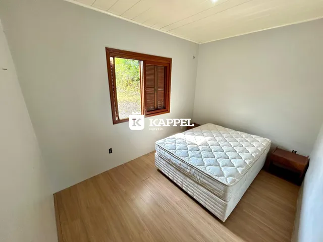 Um quarto com cama de dossel e piso de madeira clara.