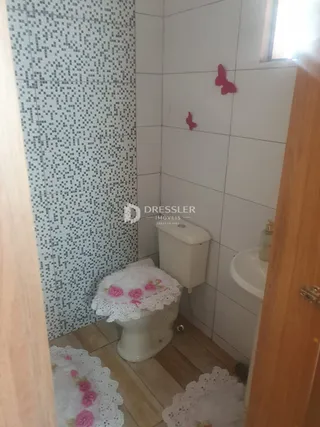 Foto de um banheiro interno com piso de madeira e azulejos brancos.