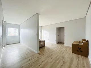 Interior de uma sala com piso de madeira clara e paredes brancas.
