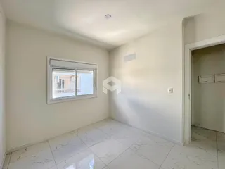 Sala de estar com piso de mármore claro e paredes brancas.