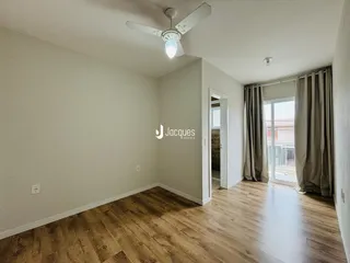 Sala de estar com piso de madeira e paredes claras.
