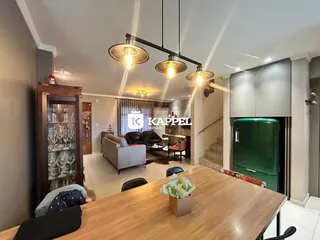 Sala de estar com móveis e área de cozinha integrada em um apartamento.