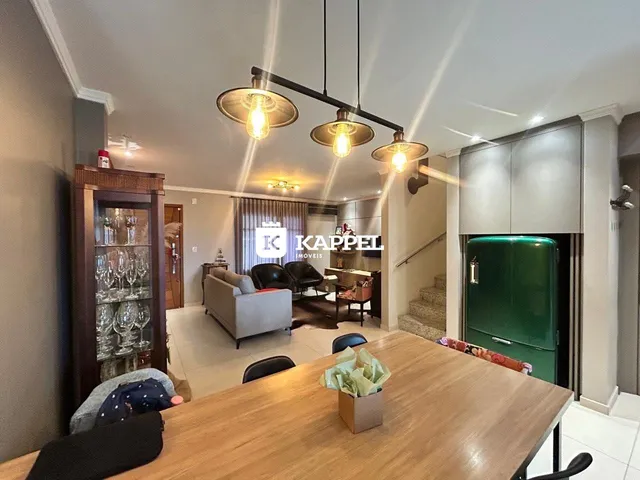 Sala de estar com móveis e área de cozinha integrada em um apartamento.
