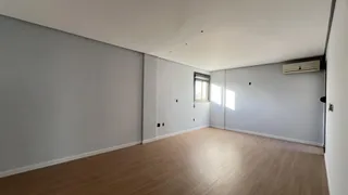 Sala ampla com piso de madeira e ar-condicionado instalado.