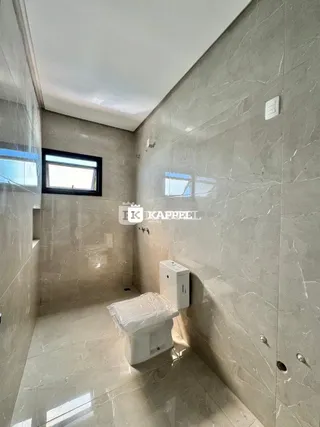Foto de um banheiro com piso de porcelanato claro e paredes revestidas.